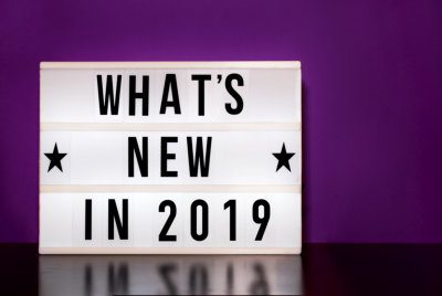 whats new in 2019 sign - cinema style lettering on light box and purple background